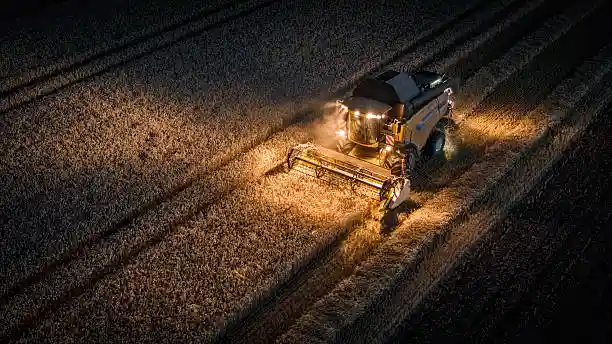 Combine harvester reel lift cylinder in field harvesting operation